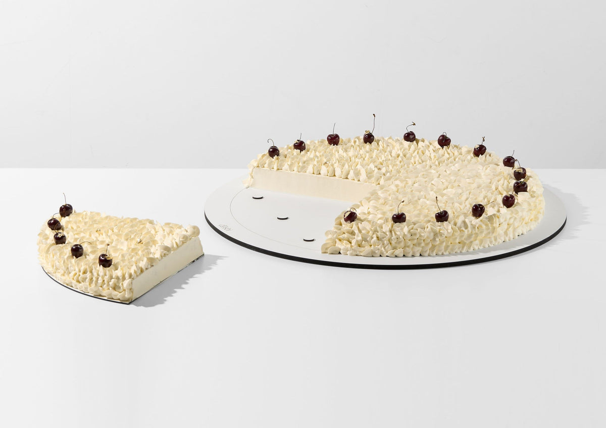 Tarta de boda redonda sobre una base desmontable por secciones, con un cuarto retirado.