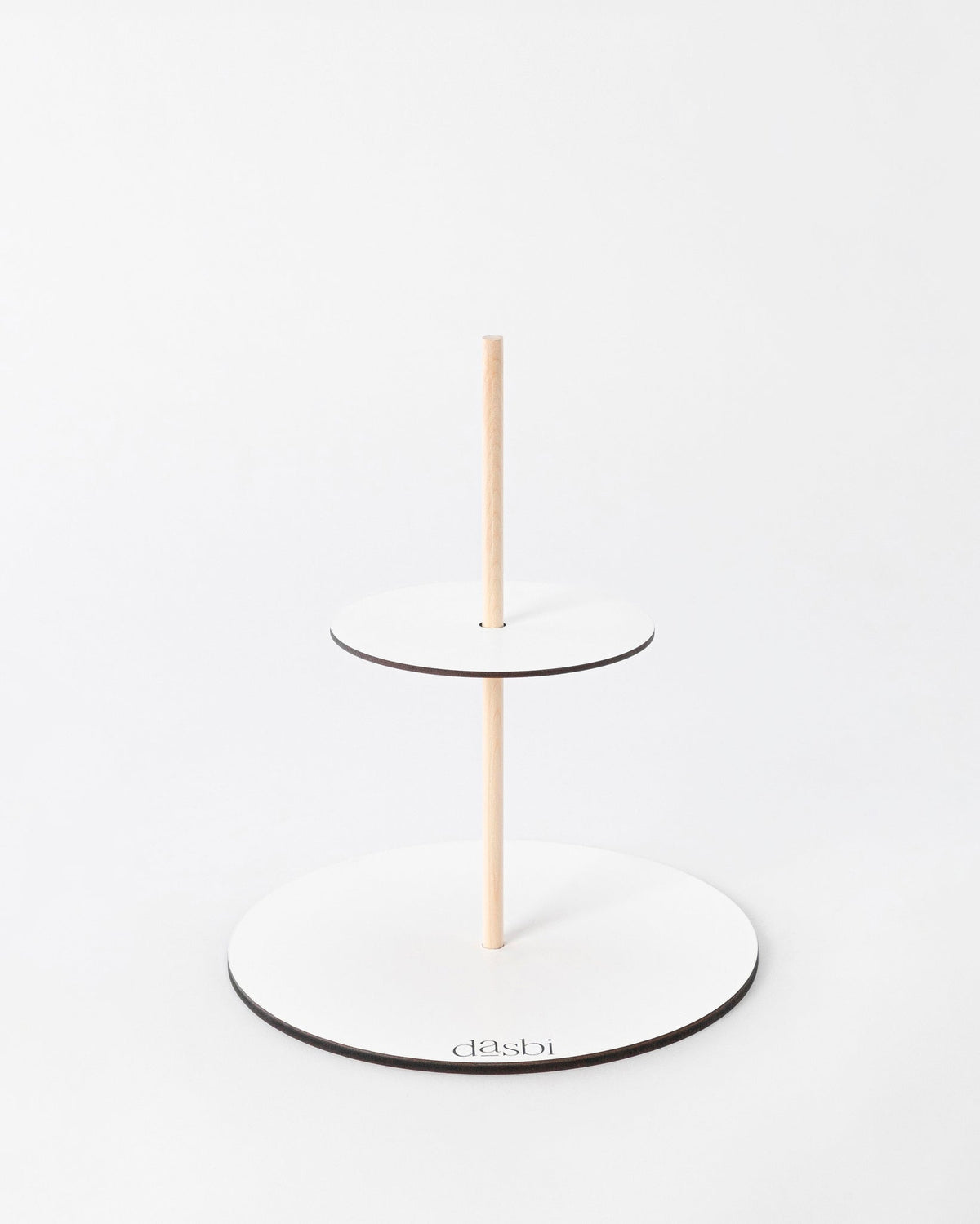 Cake structure with two round white boards joined by a central wooden dowel.