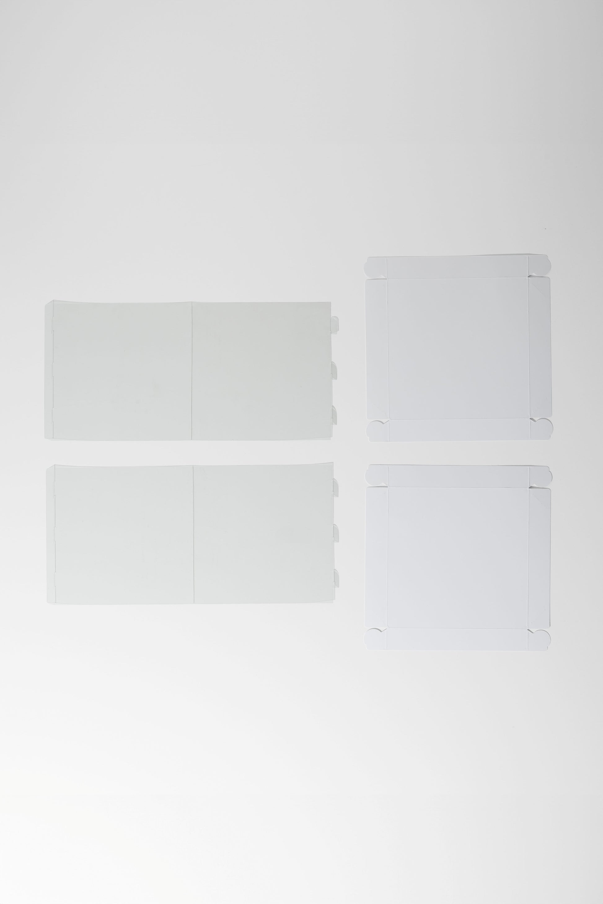 Four white square tiles on a light gray background