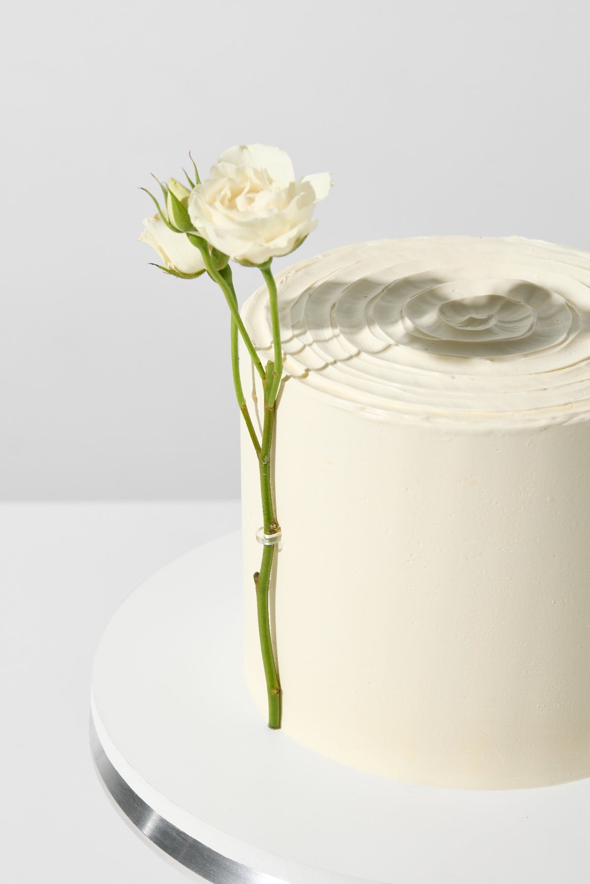 Blumen an der Tortenseite, gehalten von einem transparenten Acrylclip
